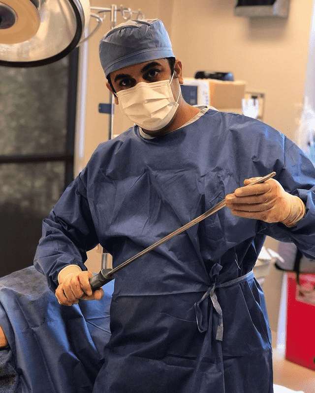 Doctor member of the team holding an instrument inside the surgery room