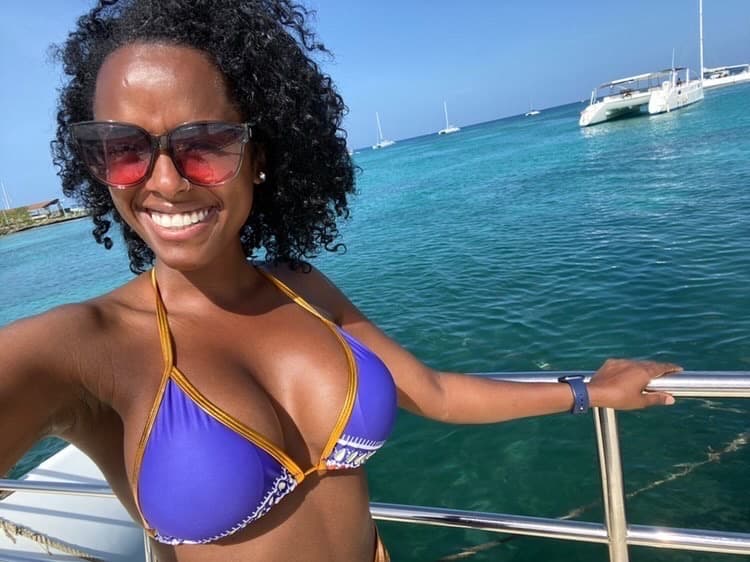 woman in blue and yellow bathing suit posing on boat