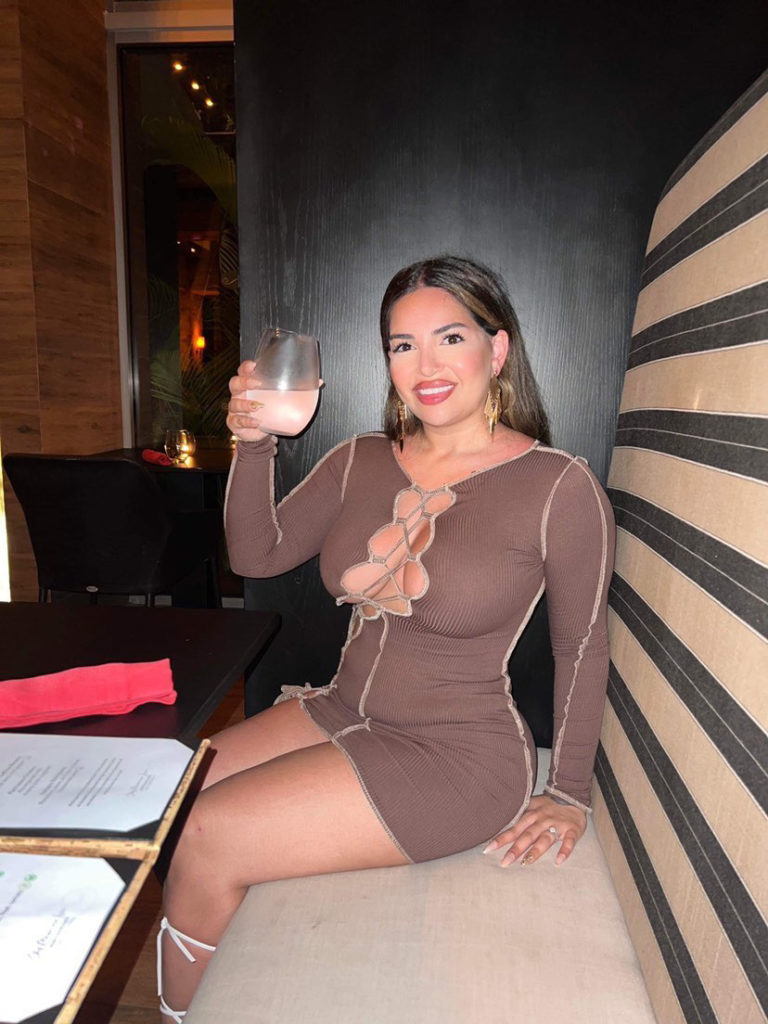 woman in brown dress sitting in booth