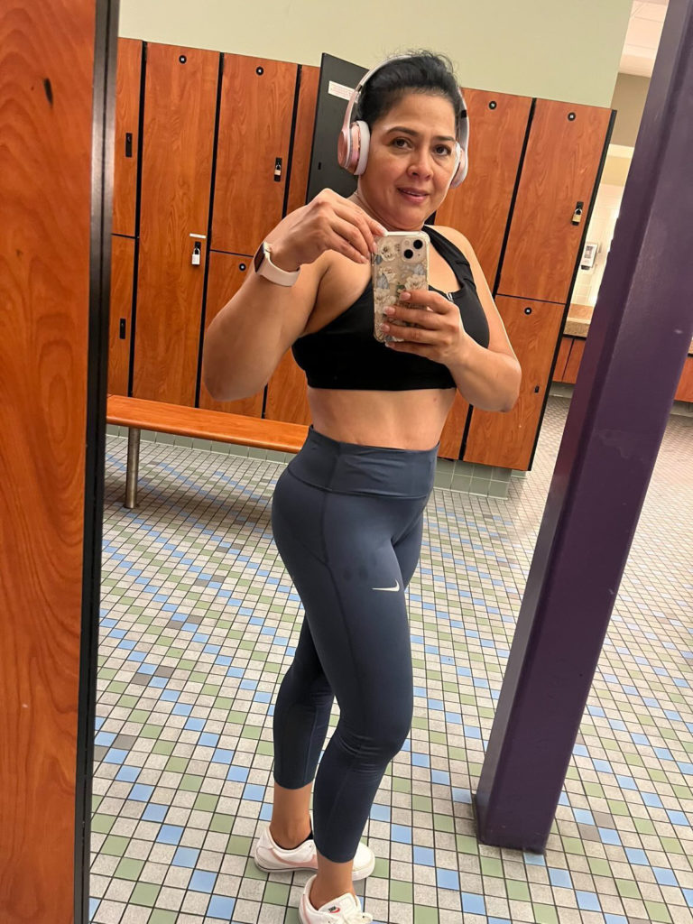 woman at gym posing for mirror selfie