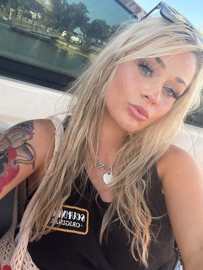 close up selfie of blond woman with arm tattoo