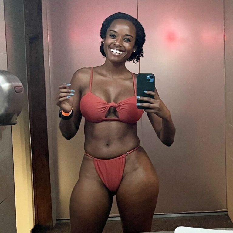 smiling woman in swimsuit in front of mirror