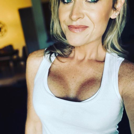 close up selfie of smiling woman in white tank top