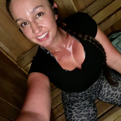 woman in black top and animal print pants smiling for selfie